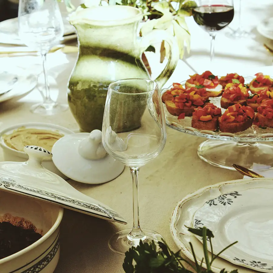 Detailed picture of a table with food, glasses and wine.